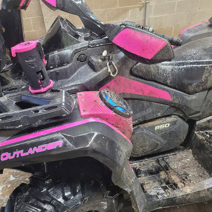 Close-up of a vehicle with pink speaker pods on a black vehicle with pink decals